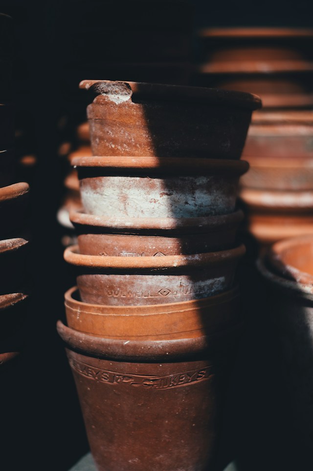 Stacked terracotta pots in shadow and light